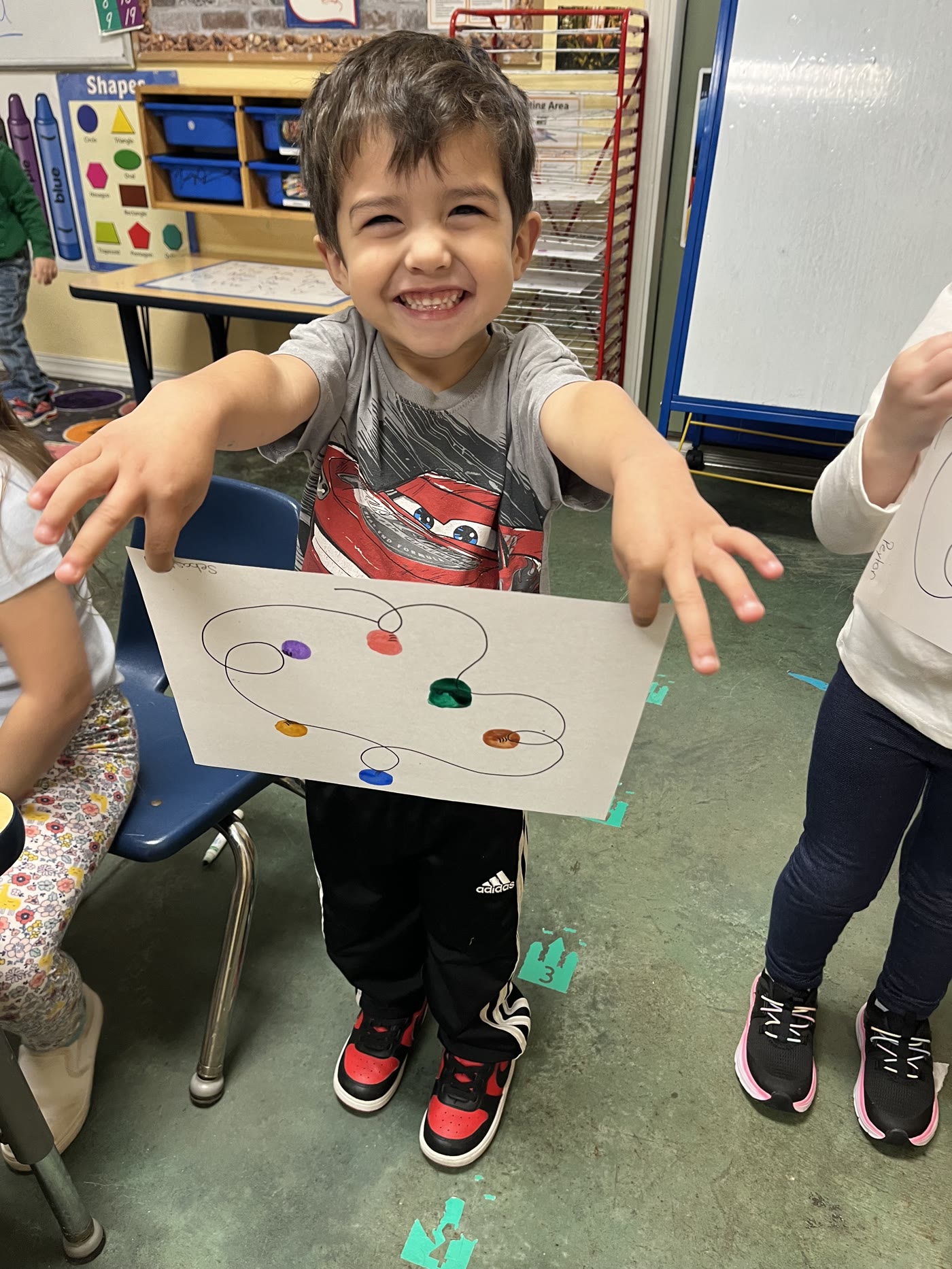 A child proudly sharing a colorful classroom project