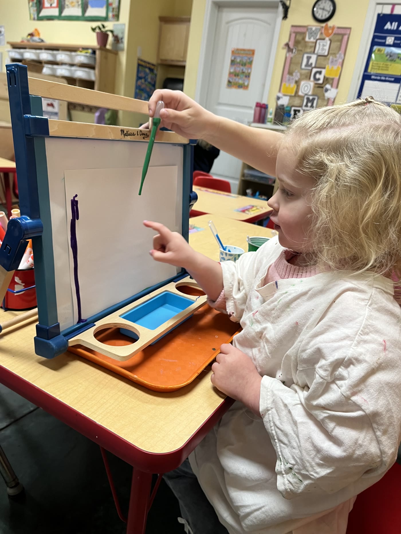 A young learner exploring colors through a guided hands-on activity
